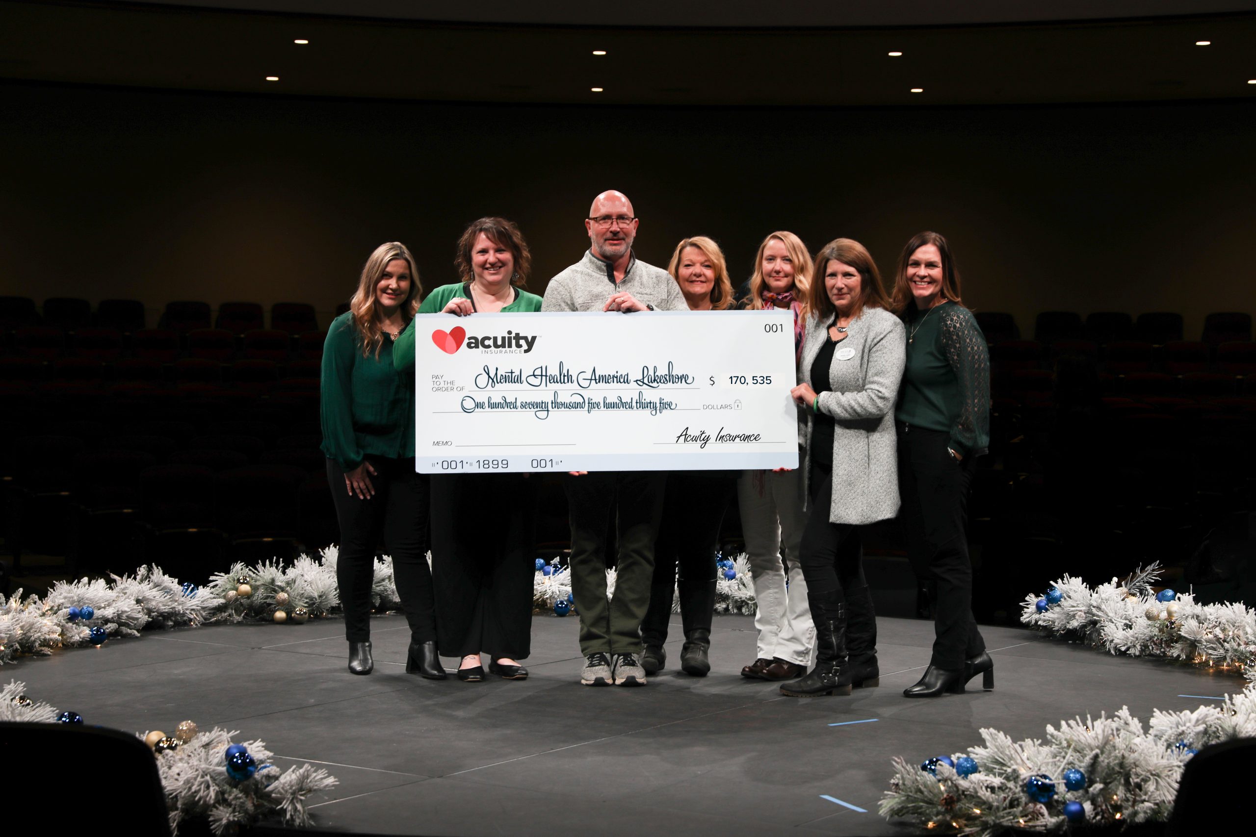 Andrea Fischer, Dawn Rousse, Mark Kesler, Liz Kesler, Julie Preder, Sandy Leske, and Anna Grunwald from Mental Health America Lakeshore accept a check for more than $170,000 from Acuity.
