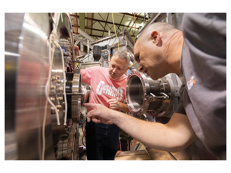 Realta co-founder Jay Anderson (left) and CEO and co-founder Kieran Furlong (right) discuss the WHAM experiment at the Physical Sciences Lab in Stoughton.
