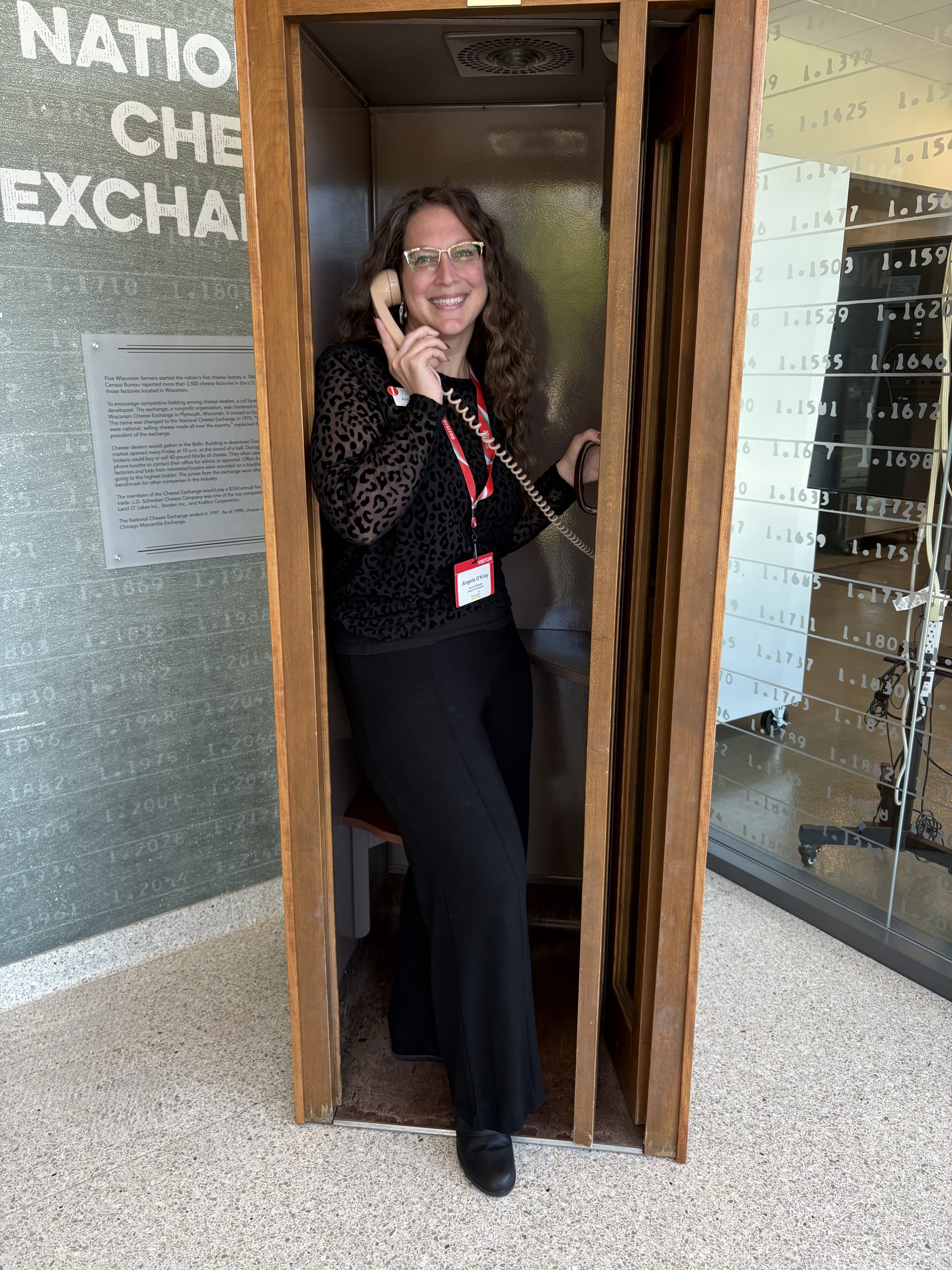 Insight General Manager Angela O'Kray stands inside the phone booth that was used in the Chicago Mercantile Exchange that Schrieber Foods used to trade cheese. Cheese trading is all done electronically these days, but Schrieber kept the phone booth.
