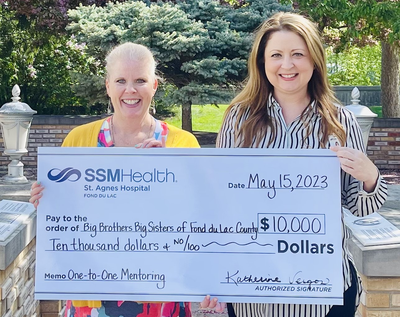 Katherine Vergos (right), SSM Health St. Agnes Hospital president, presents a $10,000 donation to Tammy Young, Big Brothers Big Sisters of Fond du Lac executive director.