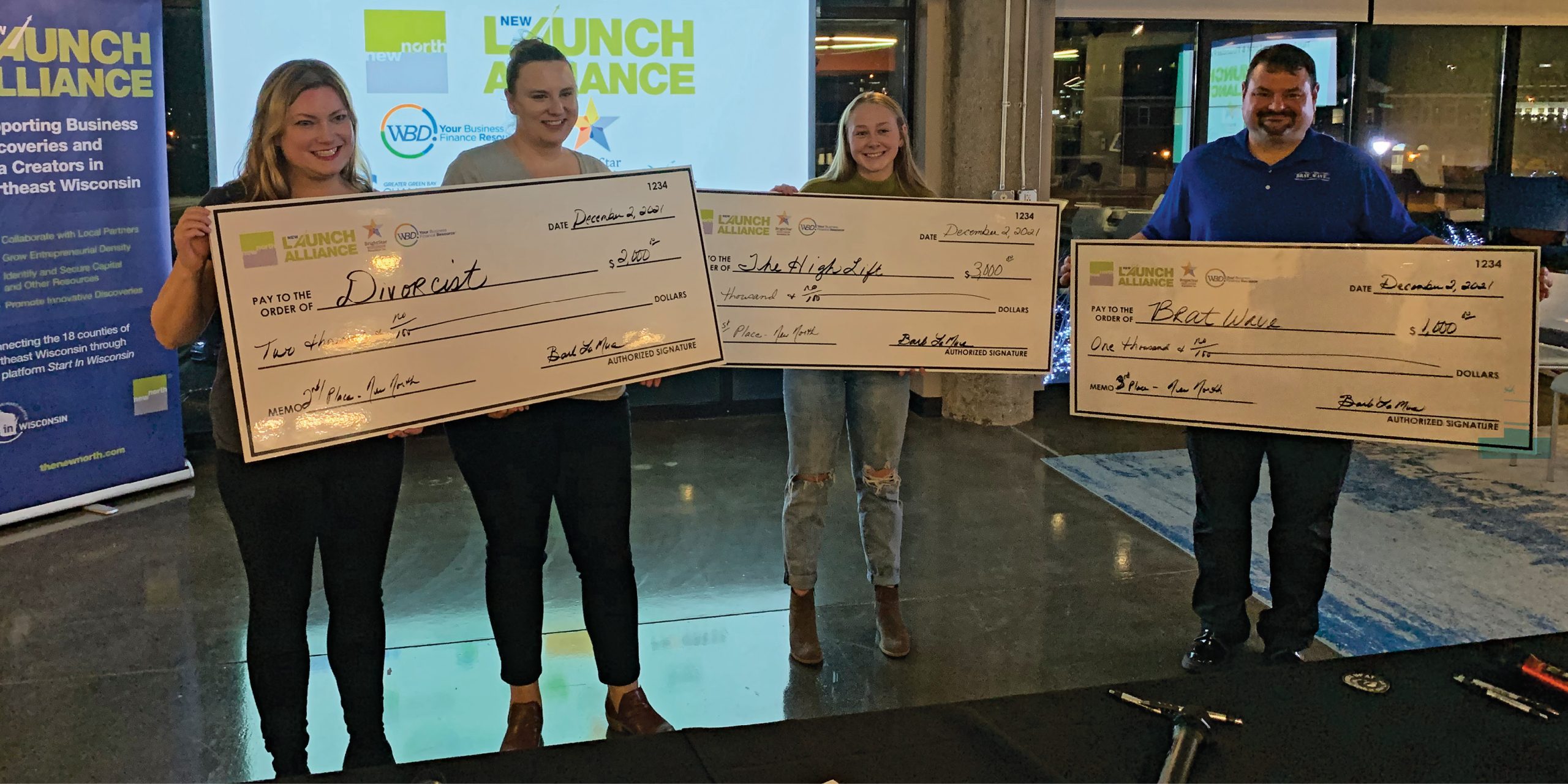 The winners of the NEW Launch Alliance Hatch pitch competition pose with their prizes. They are, from left: Divorcist, second place; The High Lift, first place; and Brat Wave, third place.