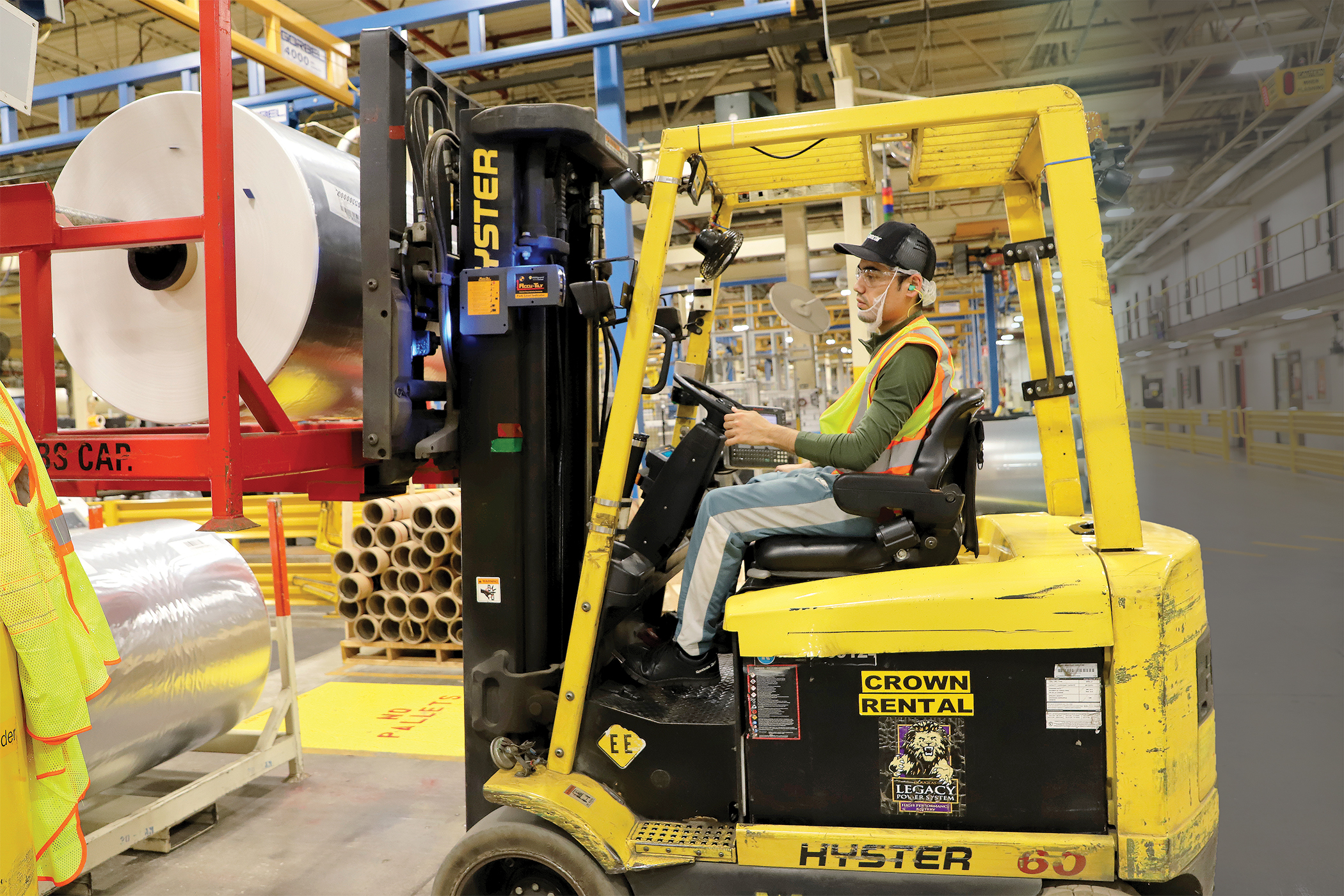 Azimullah Zarifi, rewind assistant operator, drives a forklift delivering materials and product to machines to further production at Amcor in Oshkosh.
