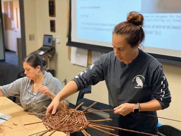 UW-Green Bay First Nations students Kathleen Ratteree and Crystal Lepscier share stories while weaving baskets during a class.