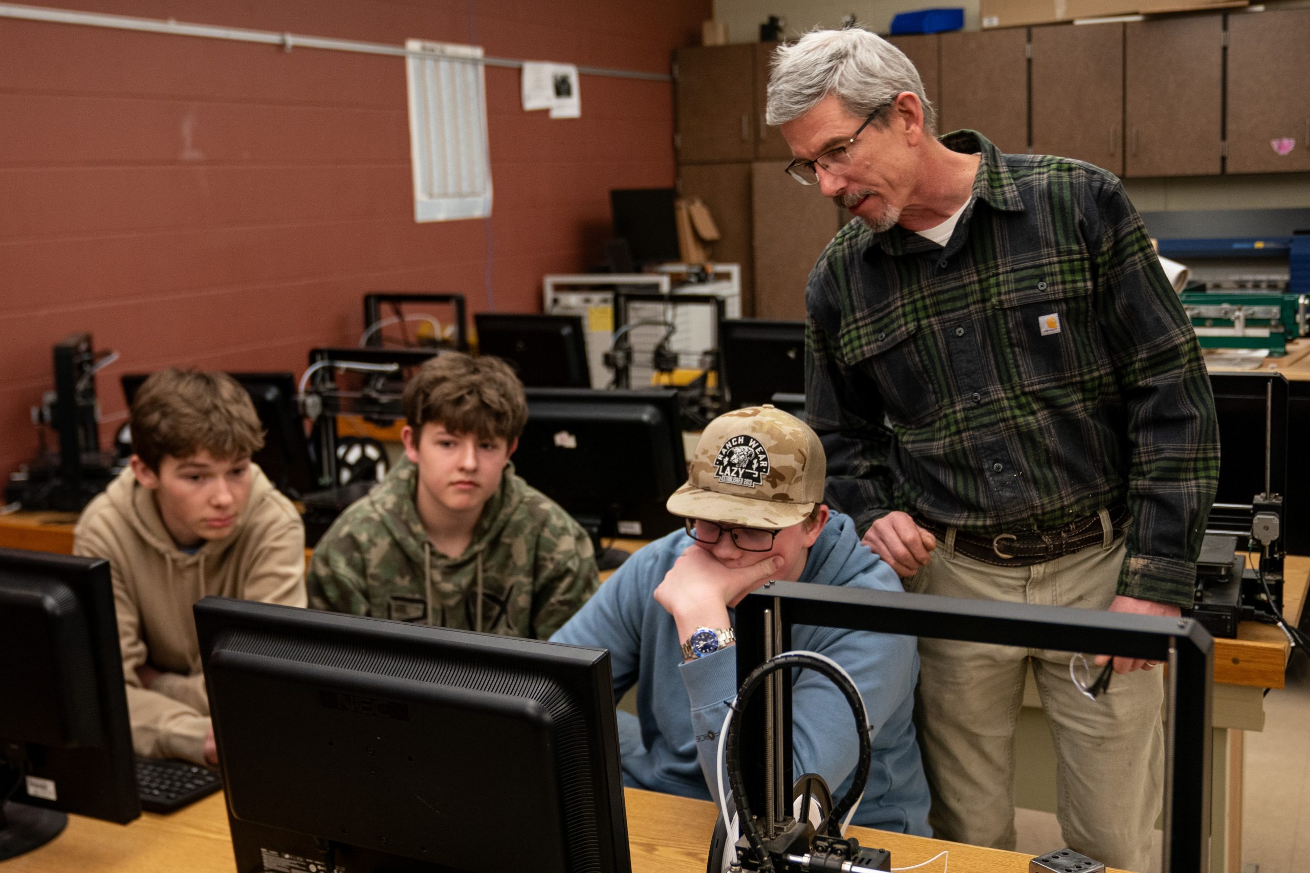 Technology and engineering teacher Laurence Charlier checks in with his students on Feb. 25, 2026, at Northwestern High School in Maple, Wis. Wisconsin lawmakers created “incentive grants” to help fund career and technical education programs statewide, bumping the allocation to $8 million in the 2023-25 biennial budget. (Erica Dischino for Wisconsin Watch)