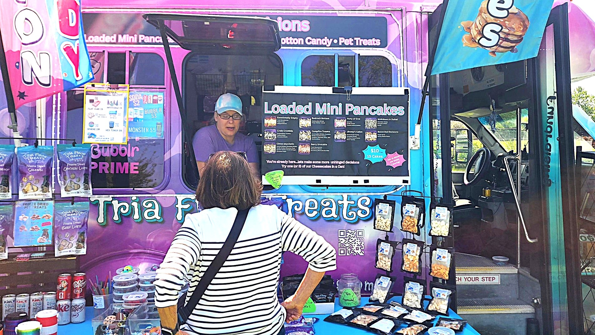 Tricia Hermsen serves a customer out of a Tria Frog Treats truck.
